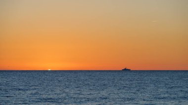Denizüzerinde turuncu gün batımı. Güneş ufukta denizde saklanır..