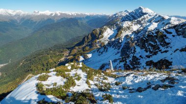 Karla kaplı sıradağların ve önündeki yeşil vadinin manzarası