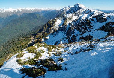 Karla kaplı sıradağların ve önündeki yeşil vadinin manzarası