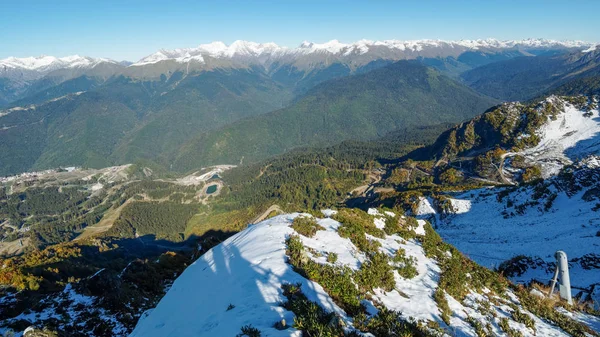Karla kaplı sıradağların ve önündeki yeşil vadinin manzarası