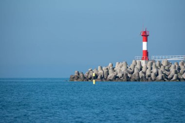 Mavi denizde bir dalgakıran üzerinde Deniz Feneri