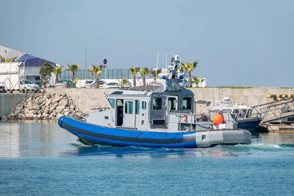 A coast guard patrol boat sails near the shore