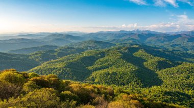 Gün batımında sis içinde dağların katmanları. Ahun Dağı'ndan görünüm, Soçi, Rusya.