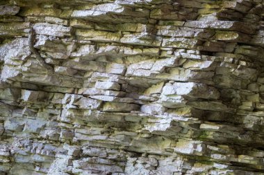 Doku, arka plan katmanları ve uçurum yüzünde tortul kaya çatlaklar. Kayalık dağ. Dağdaki kaya kayrak. Kesintisiz soyut arka plan.