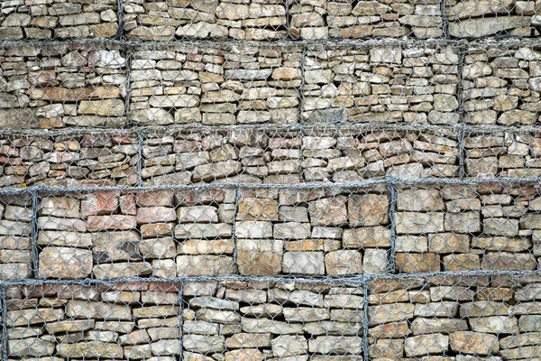 Стена Габиона из камней и камней в металлической проволоке. Забор камней в сетке. Защитная каменная стена в сетке . — стоковое фото