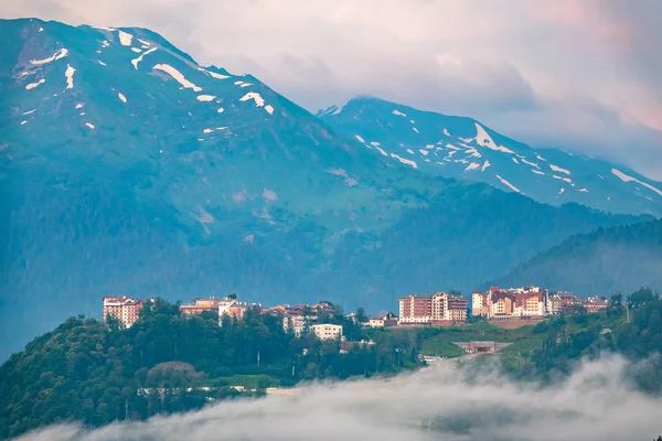 Hotel in den Bergen inmitten des grünen Waldes. Nebel in den Bergen. Krasnaja Poljana, Sotschi, Russland — Stockfoto