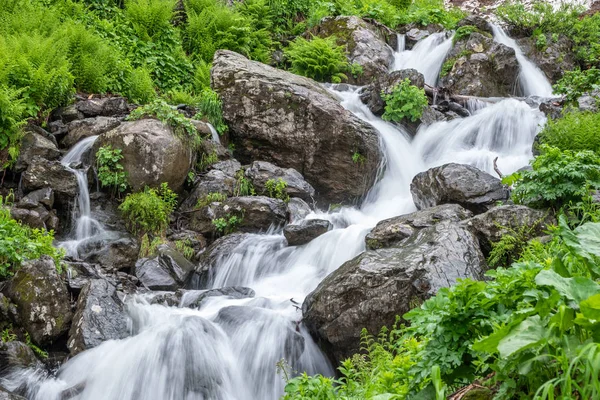 Un poderoso arroyo de montaña desciende de las rocas y piedras . — Foto de Stock