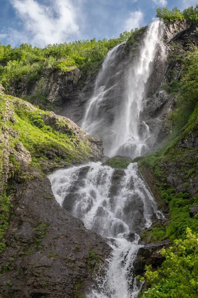 Una cascada alta cae de un acantilado en primavera o verano . — Foto de Stock