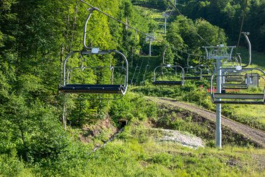 Yaz aylarında telesiyeje açılan teleferiğe sahip teleferik. Destekler ve teleferik gondollar.