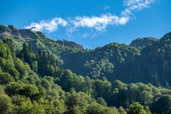 Altas montañas con pendientes verdes y telesillas . — Foto de Stock