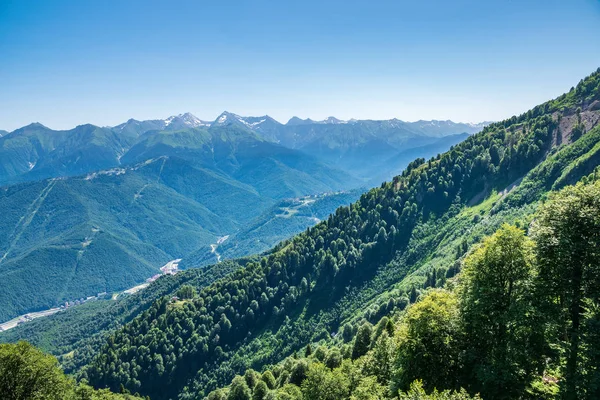 Una vista panorámica del valle con edificios de apartamentos, rodeado de montañas con teleféricos . —  Fotos de Stock