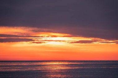 Deniz üzerinde güzel kırmızı ve turuncu gün batımı.
