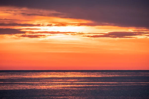 Belo pôr do sol vermelho e laranja sobre o mar . — Fotografia de Stock