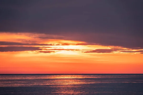 Belo pôr do sol vermelho e laranja sobre o mar . — Fotografia de Stock