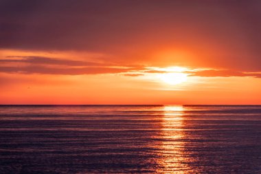 Deniz üzerinde güzel kırmızı ve turuncu gün batımı.