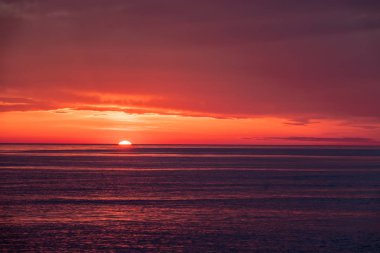 Deniz üzerinde güzel kırmızı ve turuncu gün batımı. Güneş denizin üzerinden battı..
