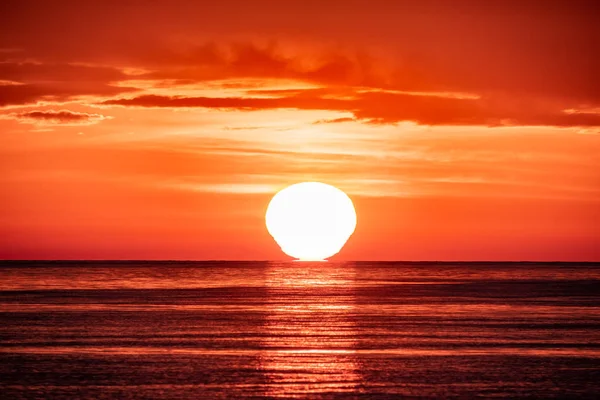 Belo pôr-do-sol vermelho e laranja sobre o mar. O sol põe-se sobre o mar . — Fotografia de Stock