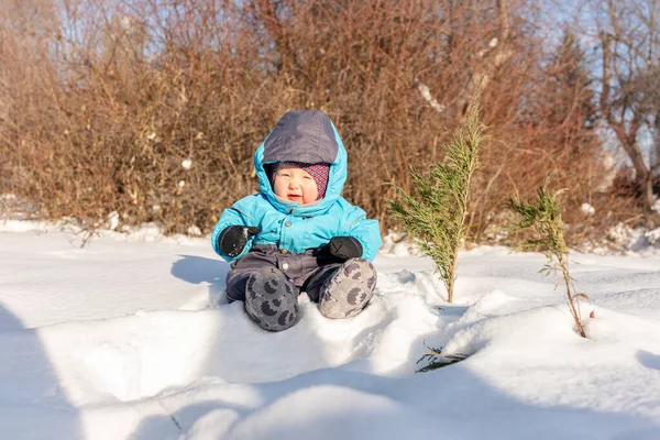 一个小孩坐在公园的雪地里 — 图库照片