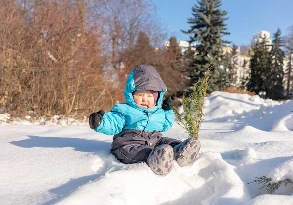 Un bambino piccolo si siede nella neve al parco — Foto Stock