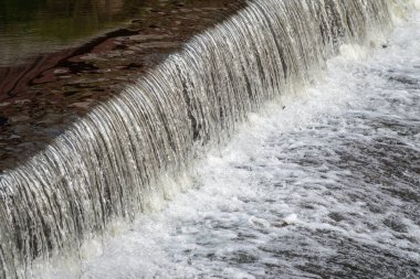 Sakin bir nehirde küçük bir şelale.