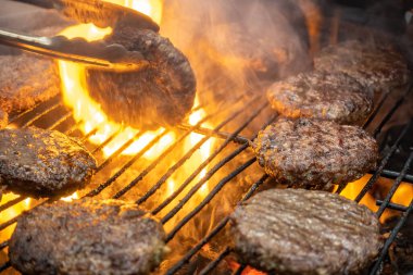 Tel askıda kömürle pişirilmiş etli biftekler. Açık havada ateşte pişmiş et. Seçici odaklanma. Yakın plan..