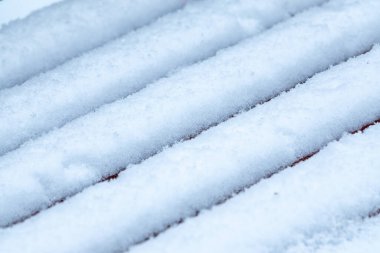 Kışın ahşap bankta taze beyaz kar yığını. Kışın dokusu beyaz kar arkaplanı.