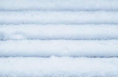 Kışın ahşap bankta taze beyaz kar yığını. Kışın dokusu beyaz kar arkaplanı.