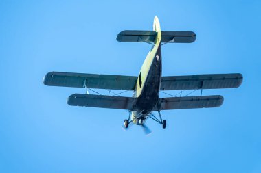 Mavi gökyüzünde yeşil çift kanatlı uçak. Mavi gökyüzüne karşı eski uçak