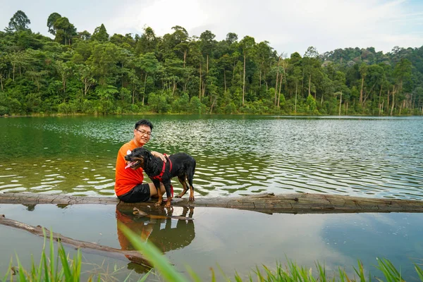 Man and dog having fun in the lake