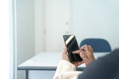 El, arama ya da sosyal ağ kavramları ile akıllı telefon yakın çekim. Office arka plan metin için yer ile