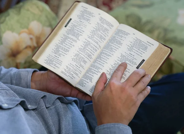 一只手放在打开的圣经的一页上 — 图库照片