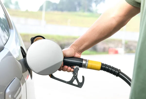 Pompage essence : Manipuler la buse de carburant pour le ravitaillement . — Photo