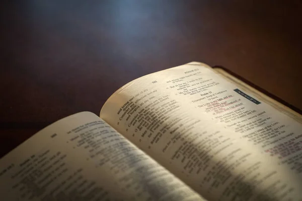 Bible ouverte sur une table en bois sombre — Photo