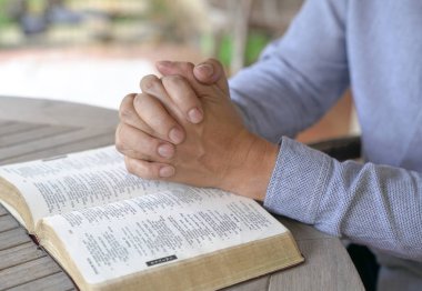 Dua: Erkek el birlikte açık bir İncil'in üzerine sıktı