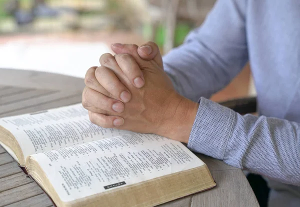 Oración: manos masculinas unidas en una biblia abierta — Foto de Stock