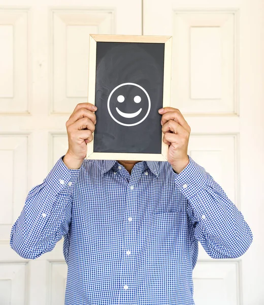 Empresario sosteniendo un tablero con una sonrisa — Foto de Stock