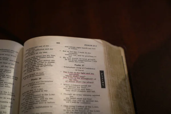 Biblia aberta em uma mesa de madeira escura — Fotografia de Stock