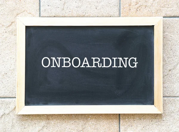 Onboarding, ord som skrivs ut på en svart tavla Royaltyfria Stockbilder