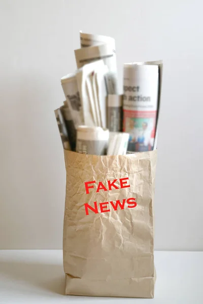 Fake news concept :  a paper bag filled with newspapers and the