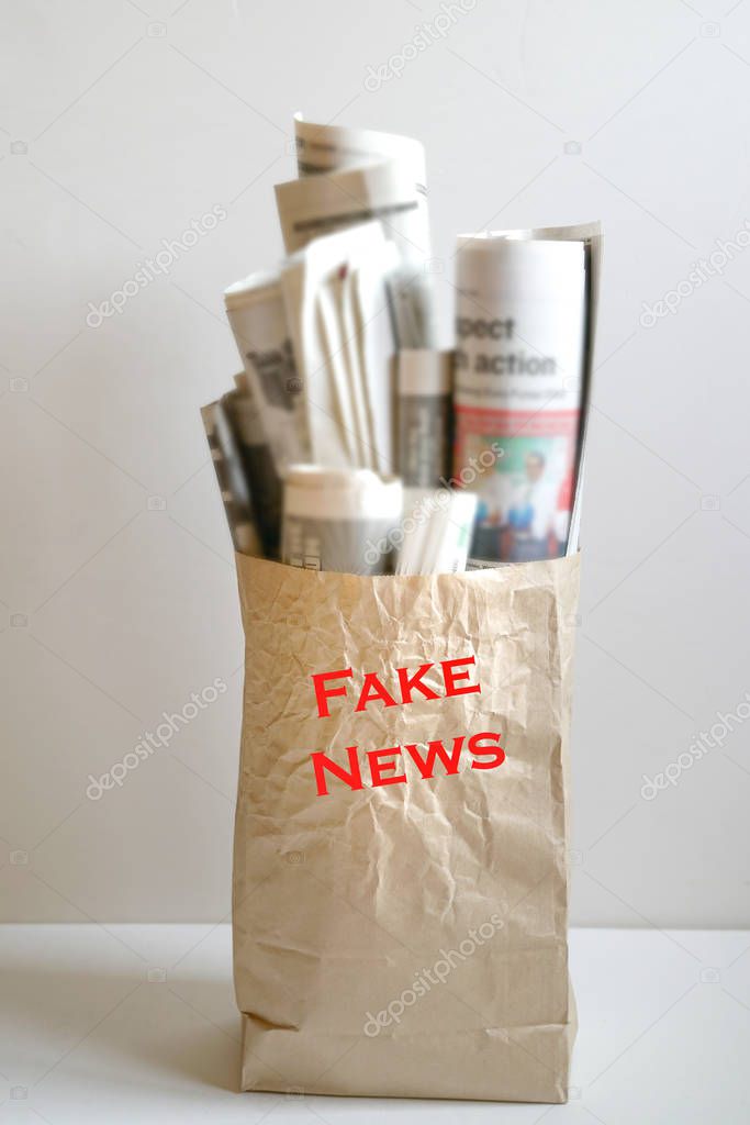 Fake news concept :  a paper bag filled with newspapers and the 