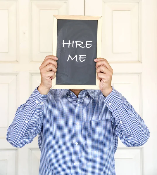 「Hire Me」と書かれたボードを持つ男が印刷された — ストック写真