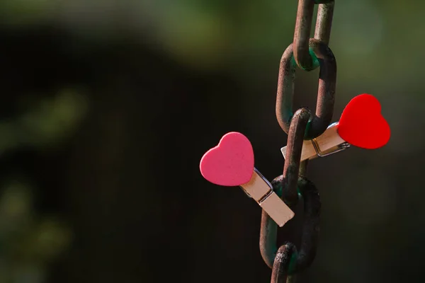 Love concept: Two clips with heart shape on a steel chain — Stock Photo, Image