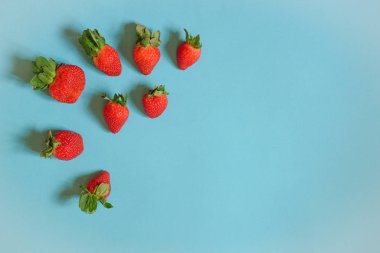Arka plan: tatlı kırmızı çilek mavi zemin üzerine
