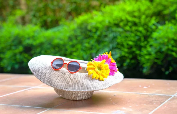 Strand mössa med solglasögon och Gerbera daisy blommor — Stockfoto