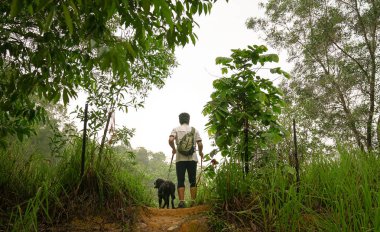 Bir tepenin üstündeki adam ve köpek ayakta