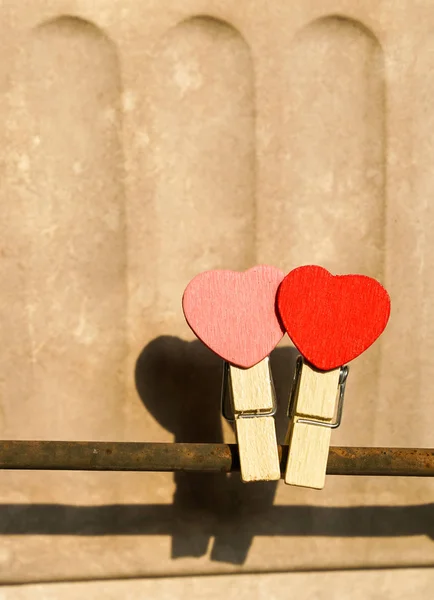 Love concept: Two clips with heart shape on a steel bar — Stock Photo, Image