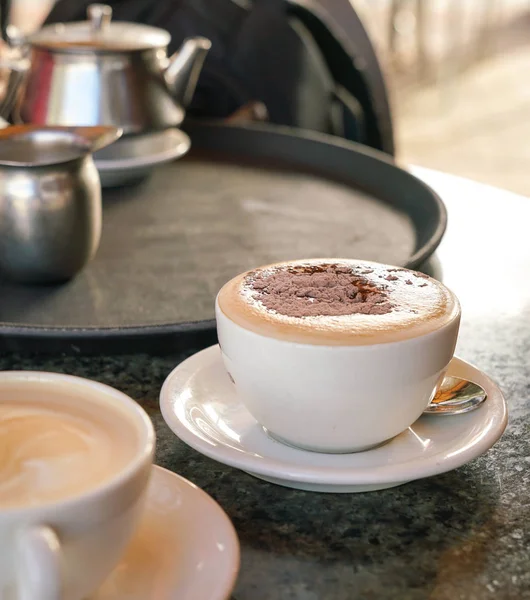 Xícara de cappucino na mesa em um café — Fotografia de Stock