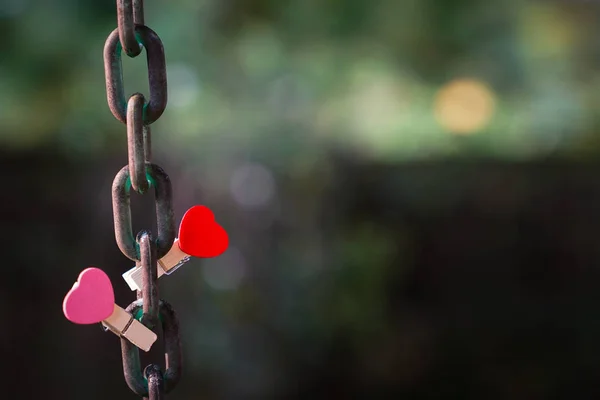 Love concept: Two clips with heart shape on a steel chain — Stock Photo, Image