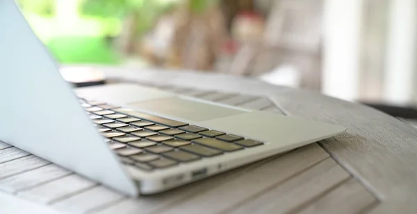 Laptop em uma mesa de madeira, jardim ou fundo ao ar livre . — Fotografia de Stock