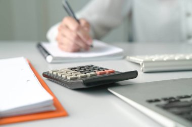 Office table view with Accountant or Woman Executive out of focu